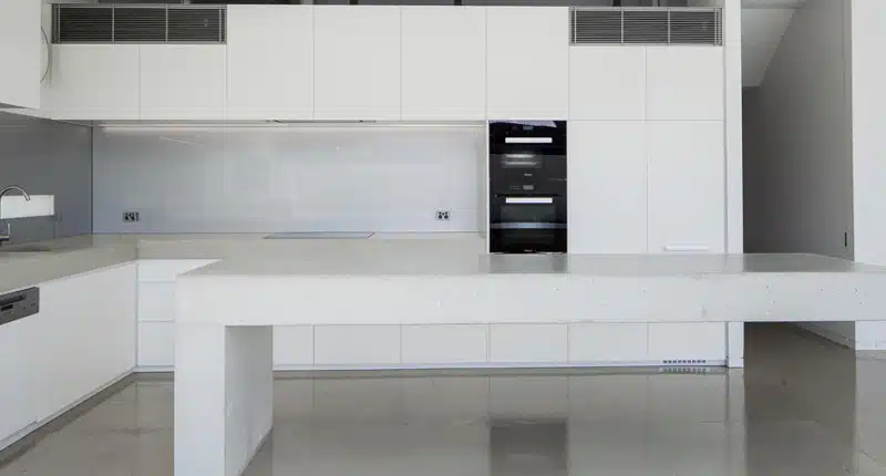 Minimalist White kitchen with polished concrete floors in South Yarra