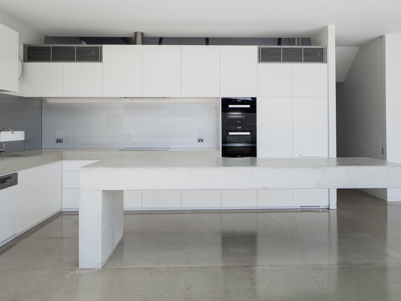 Minimalist White kitchen with polished concrete floors in South Yarra