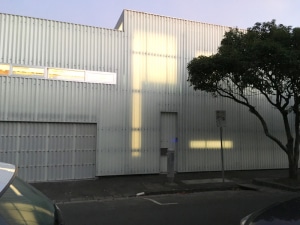 Street view of industrial style corrugated iron facade and garage door